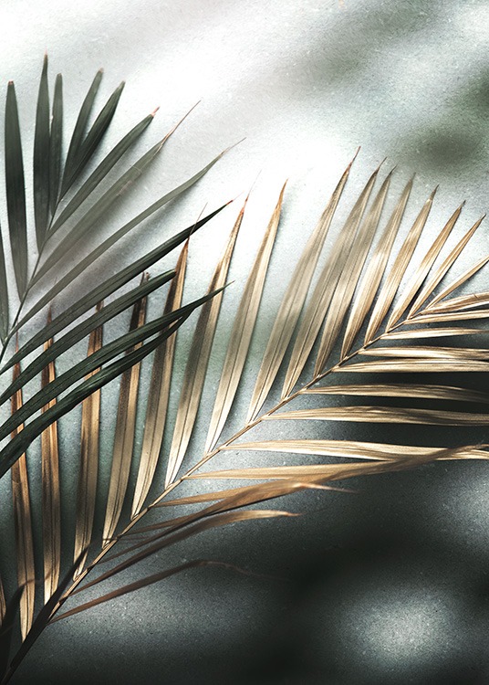  – Fotografi av et par palmeblader i gull og grønt mot en steinbakgrunn