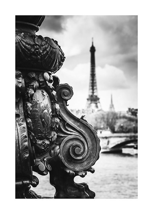  - Fotografi av detaljer fra en bro foran Eiffeltårnet, i svarthvitt