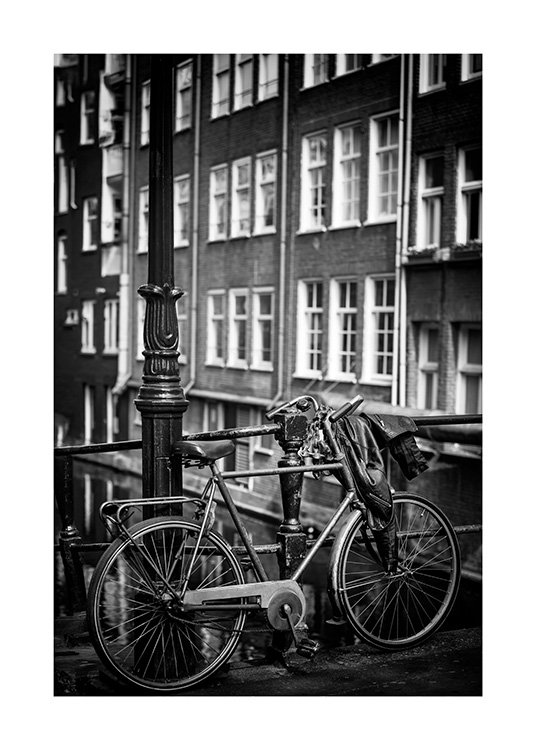  - Svarthvitt-fotografi av en lyktestolpe ved siden av en parkert sykkel, foran et hus med vinduer