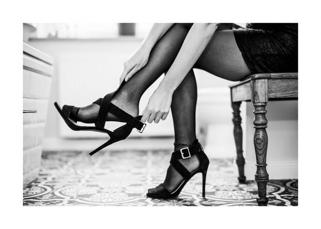  – Svarthvitt-fotografi av en kvinne som tar på seg et par høyhælte sko