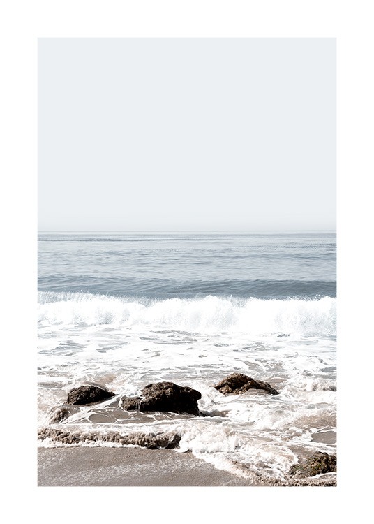  – Fotografi av bølger som slår mot en strand med steiner