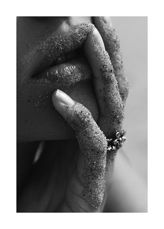  – Svarthvitt nærbilde av en kvinne med sand på leppene og fingrene