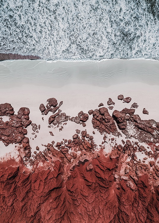  - Flyfoto av en strand med røde steiner og rød sand