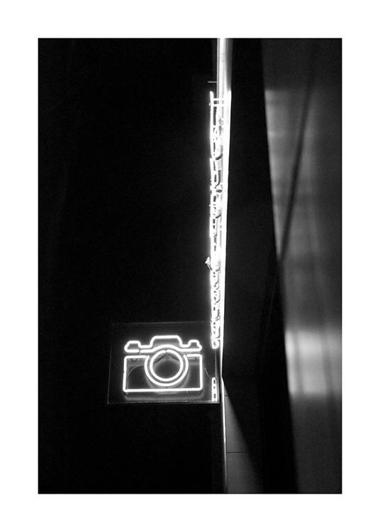 - Svart-hvitt fotografi av et neonskilt som er formet som et kamera