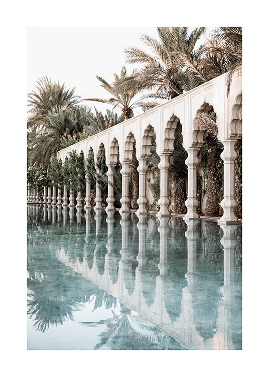  - Fotografi av hvite søyler og buer ved siden av et basseng, med palmer i bakgrunnen