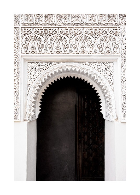  - Fotografi av en svart dør og en hvit bue med håndlagde detaljer og mønstre