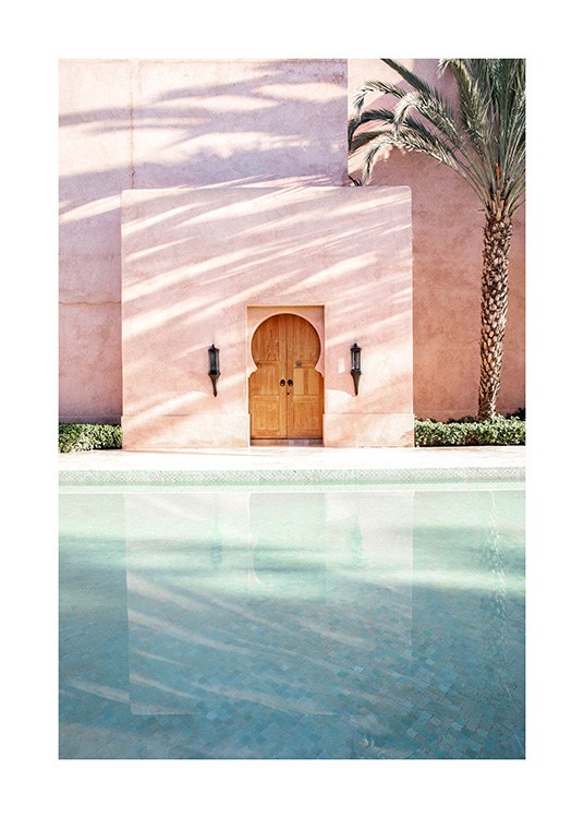  - Fotografi av en palme ved siden av en rosa bygning med et basseng foran
