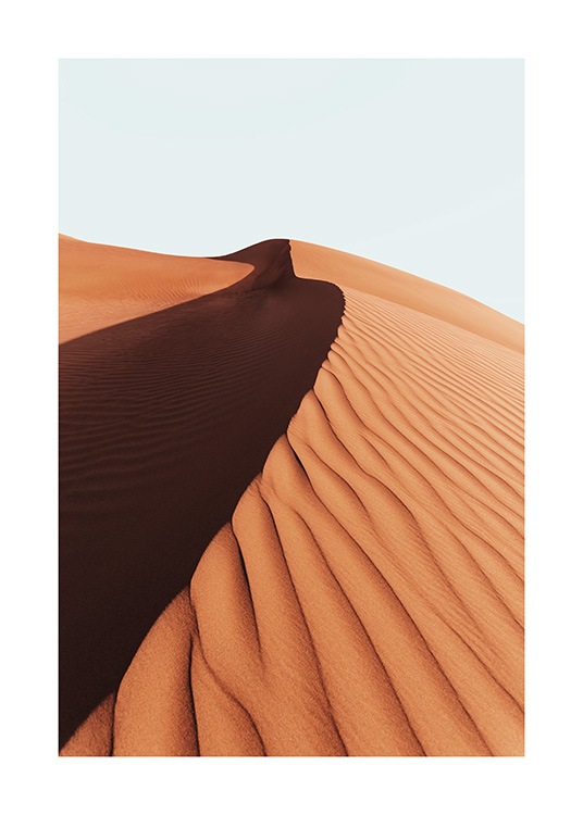  – Fotografi av en sanddyne i ørkenen, med en lyseblå himmel i bakgrunnen