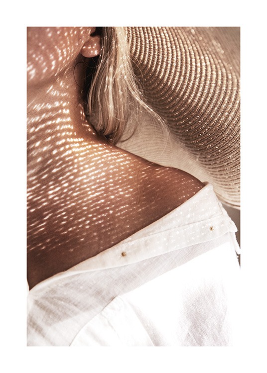  – Fotografi av en kvinne iført en hvit skjorte og en solhatt
