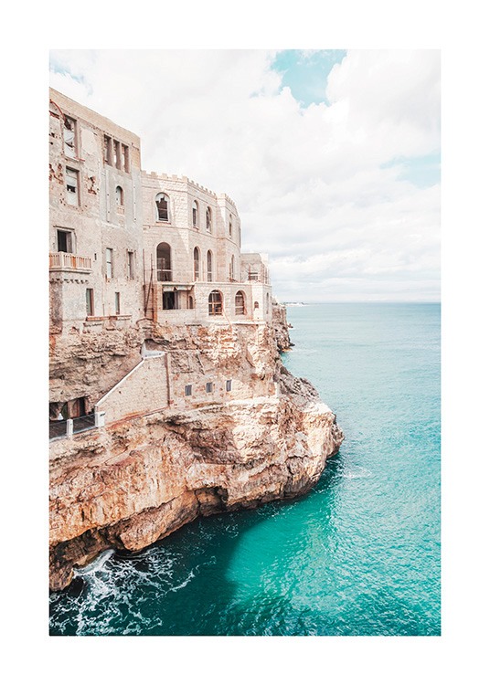  – Fotografi av en klippe ved et hav, med en bygning på klippen
