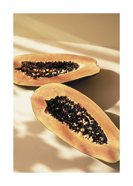  – Fotografi av en papaya delt i to, mot en gul bakgrunn