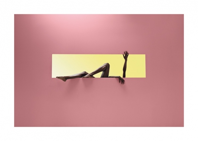 – Fotografi av en kvinne i en gul rektangel mot en rosa bakgrunn, som strekker ut armene og beina