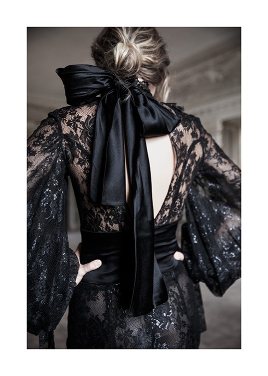  – Fotografi av en kvinne iført en svart blondekjole med svart satengsløyfe i nakken