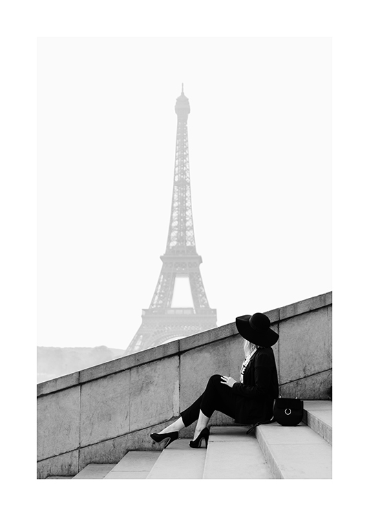  – Svarthvitt-fotografi av en kvinne som sitter på en trapp, med Eiffeltårnet i bakgrunnen