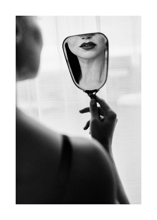  – Svarthvitt-fotografi av en kvinne med mørk leppestift, som ser på seg selv i et lite speil