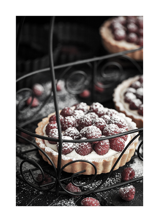  – Fotografi av kaker med bringebær og melis på et metallbrett med utskjæringer