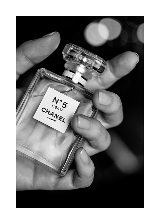  – Svarthvitt-fotografi av en flaske med Chanel No5-parfyme som holdes av en hånd