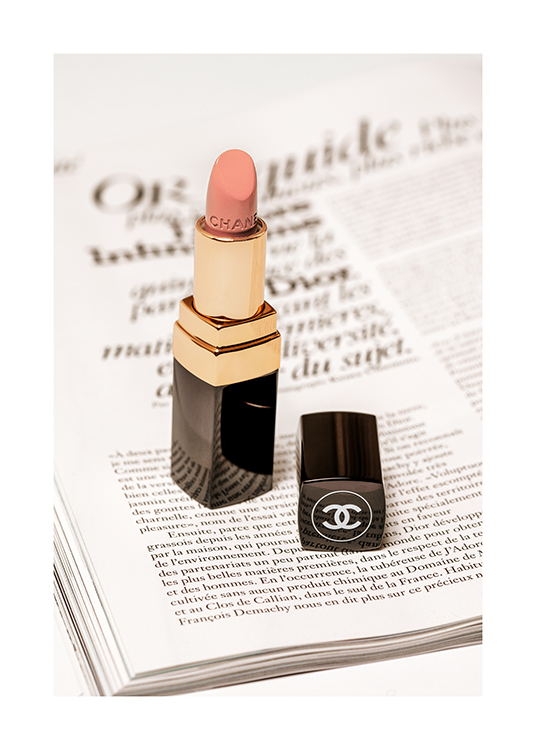  – Fotografi av en lyserosa Chanel-leppestift med en side fra en bok under