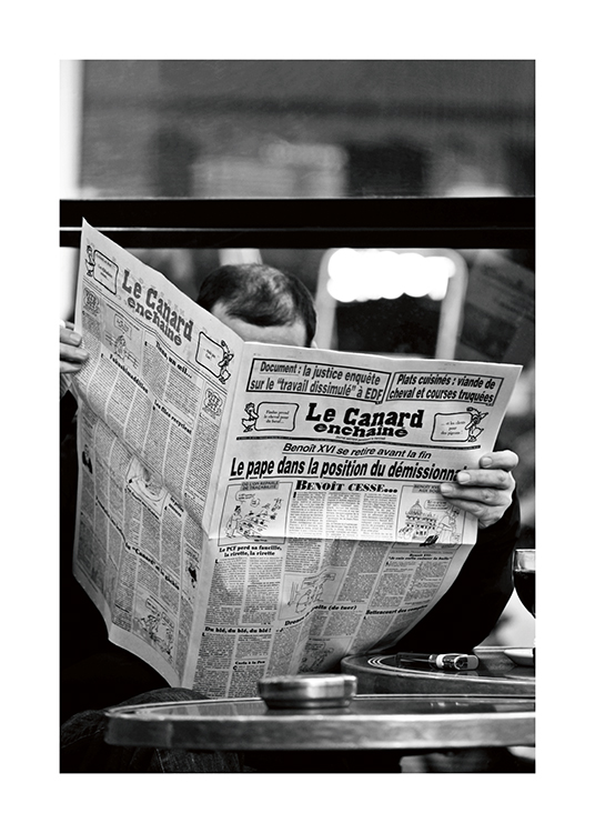  – Svarthvitt-fotografi av en mann som leser avisen Le Canard enchainé