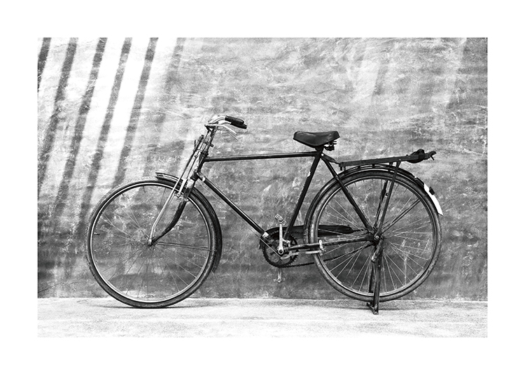  – Svarthvitt-fotografi av en gammel vintage-sykkel som står lent mot en vegg