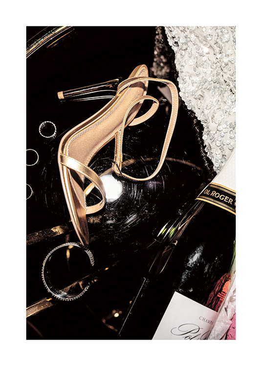  – Et fotografi av champagne gullfargede høyhælte sko, sølvfargede smykker og en paljettkjole