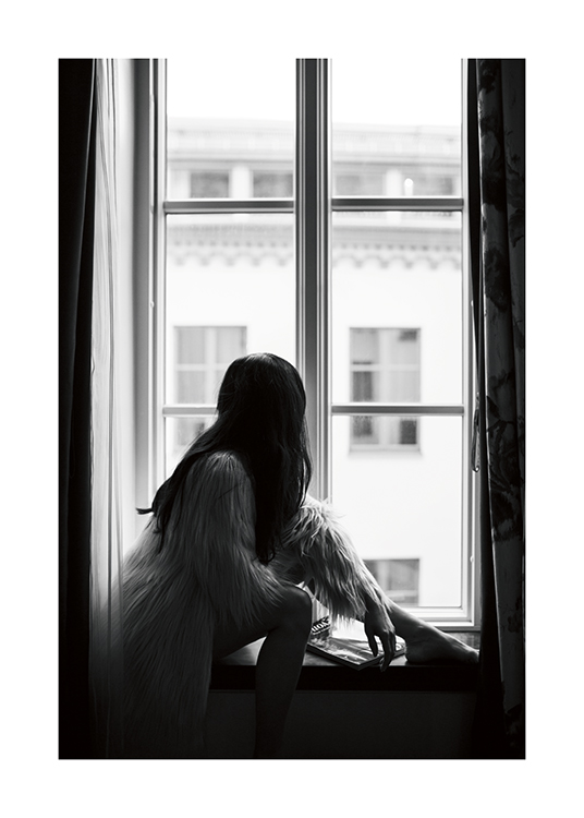  – Et svarthvitt-fotografi av en mørkhåret kvinne som sitter i en vinduskarm, iført en kunstpels