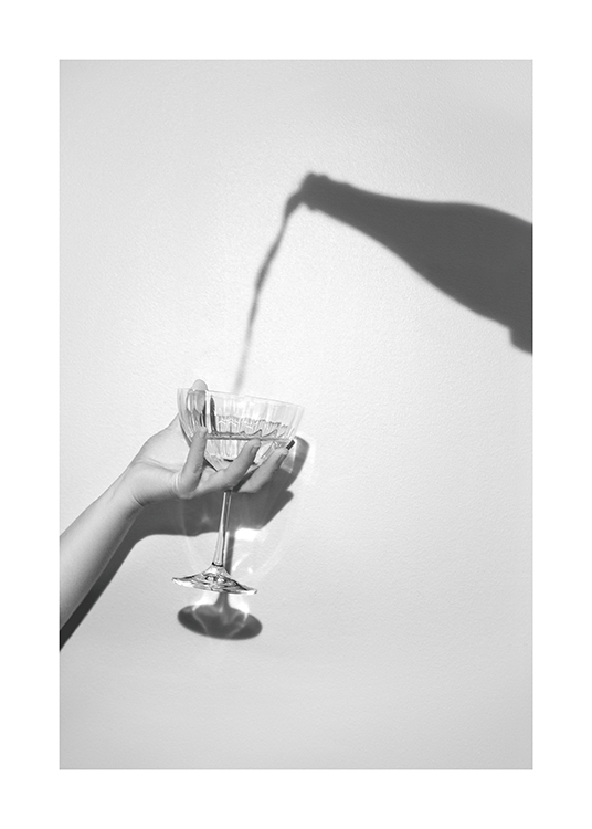  – Grått fotografi av en skygge av en champagneflaske og en hånd som holder et champagneglass