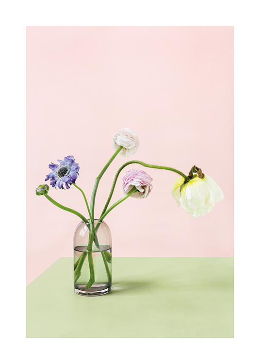  – Fotografi av fargerike blomster i en vase som står på et grønt bord