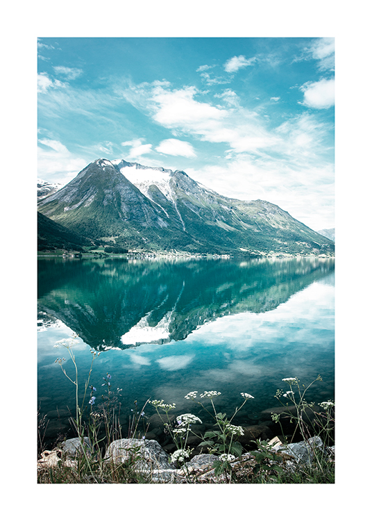  – Fotografi av et fjell som speiler seg i en rolig innsjø, med blomster i forgrunnen