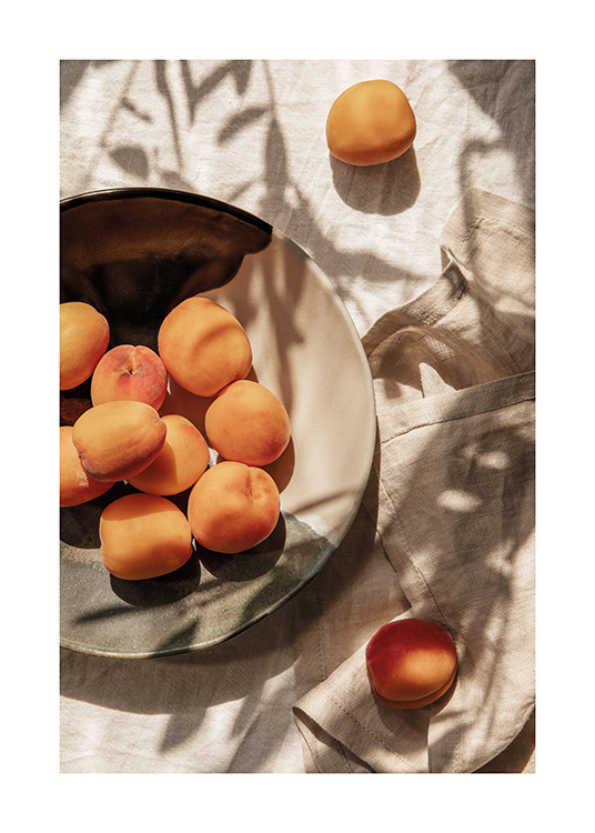  – En tallerken med nyplukkede aprikoser lagt fram på et middagsbord