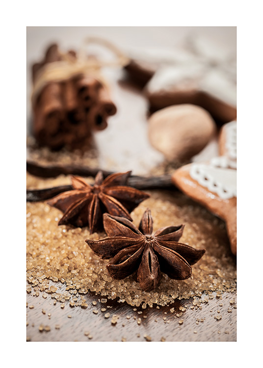  – Fotografi av kanelstenger og stjerneanis som ligger på brunt sukker