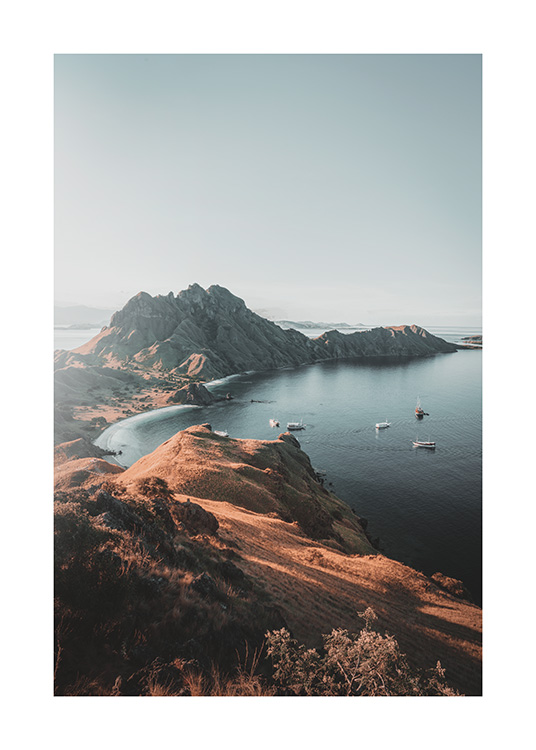  – Fotografi av båter i havet ved siden av store klipper ved øya Padar i Indonesia