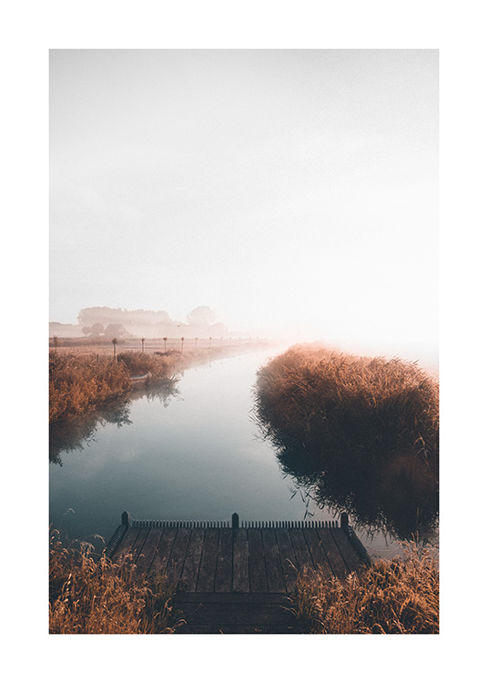  – Fotografi av en rolig innsjø med et tåkete landskap i bakgrunnen og en liten brygge i forgrunnen
