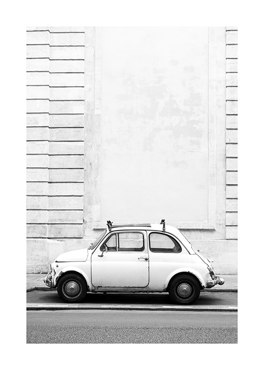  – Svarthvitt-fotografi av en liten veteranbil som er parkert foran en bygning med en stripete effekt