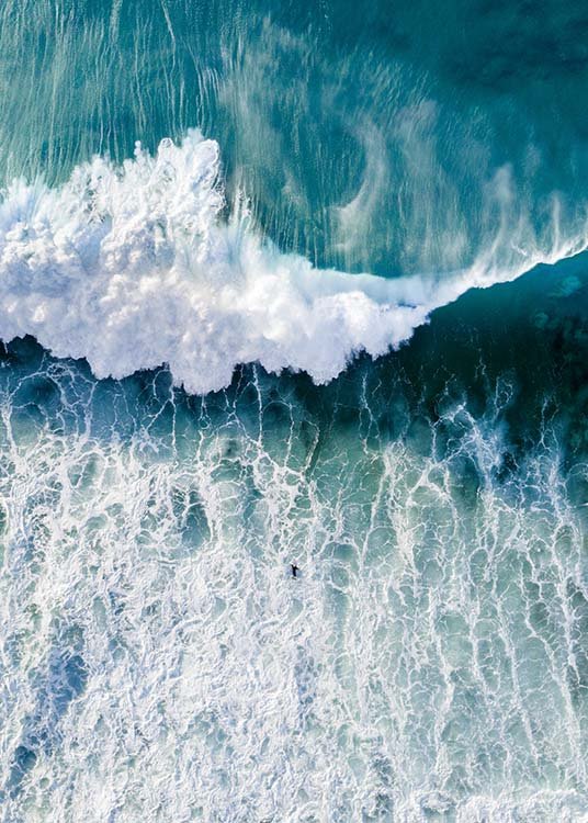  – Flyfoto av et hav med en stor bølge som kommer mot en surfer