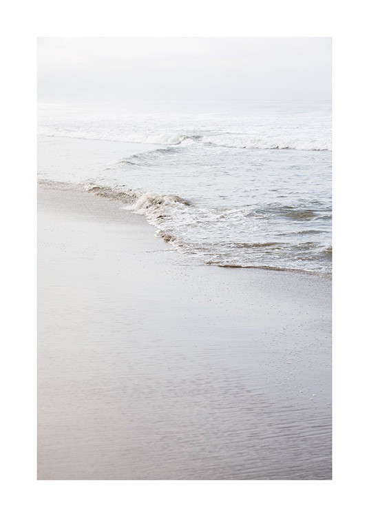  - Fotografi av en strand og en rolig strandlinje med en liten bølge
