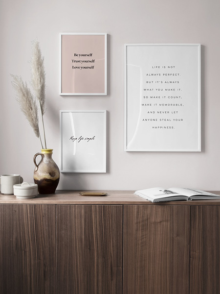 Moderne tekstplakater. Tre posters med qoutes innrammet på en vegg.